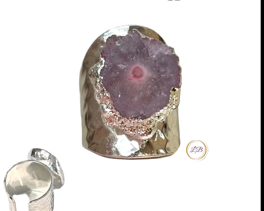 Solar geode adjustable ring with purple geode center and silver metal casing on a glittery background.